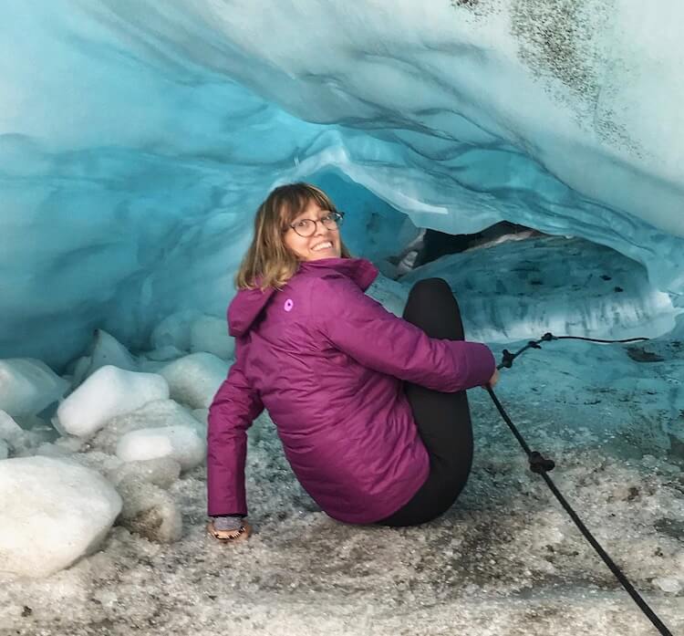 Me, sitting down, hanging on to a rope and climbing into a glacier cave