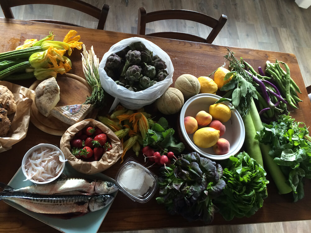 fruit, vegetables and fish spread out on a farm table