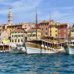 boat in front of colorful buildings in the harbor of Rovinj