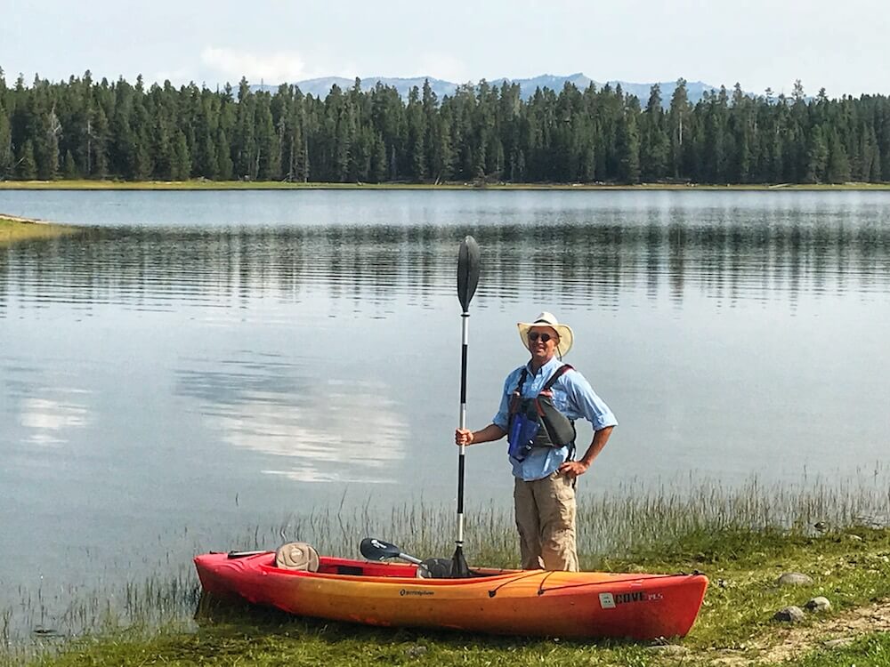 man next to a kayak