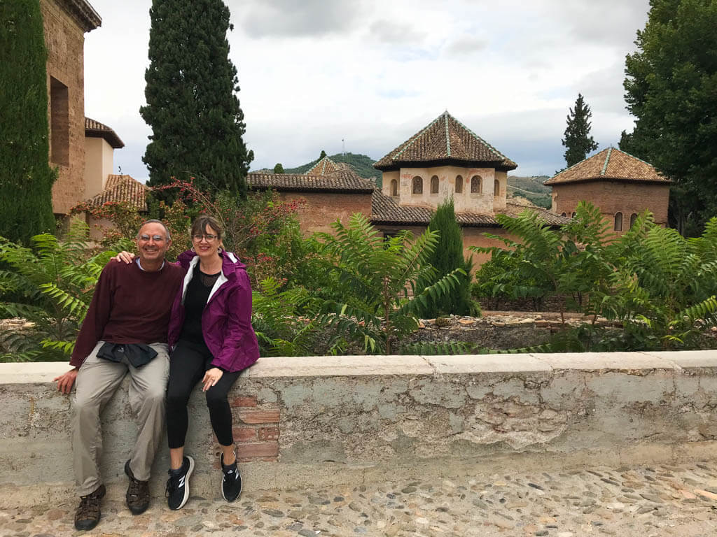 couple sitting on the wall at alhambra palace in Granada