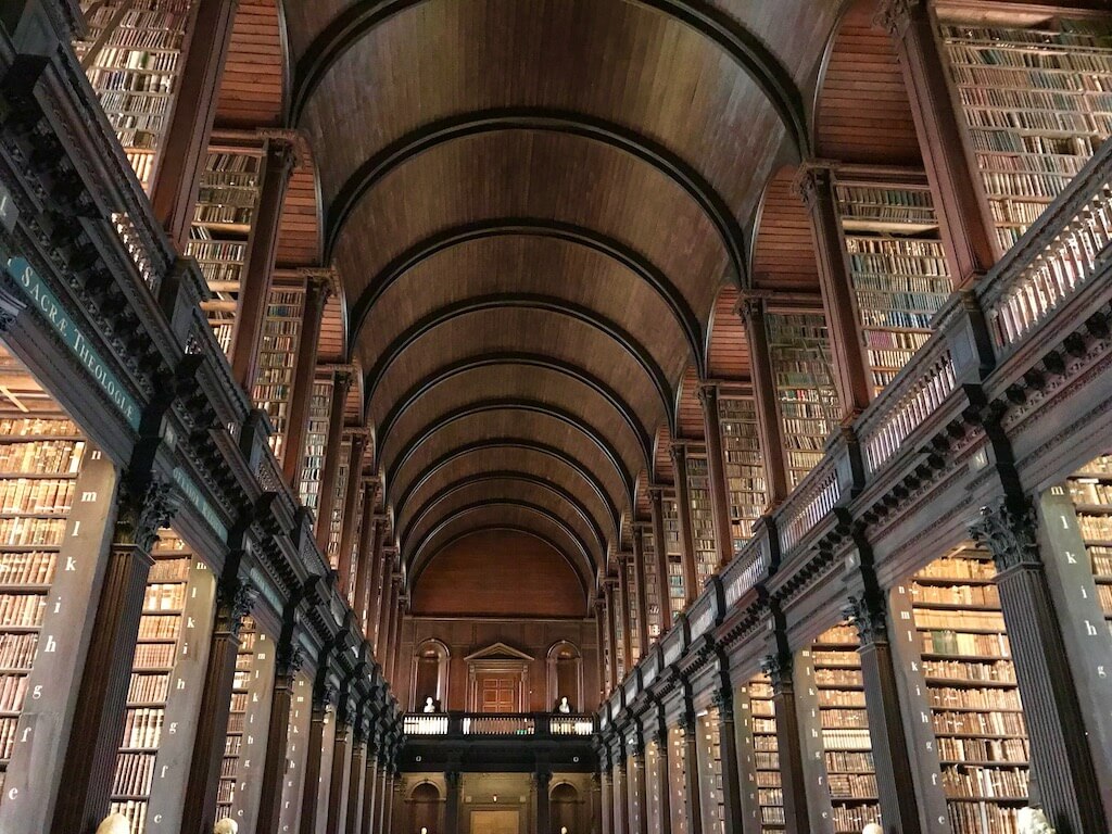 medieval books stacked floor to ceiling in Trinity Colleg'es Long Hall