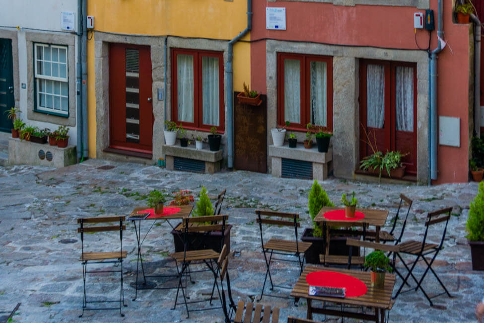 red chairs on a cobblestoned street in front of colorful building facades in Porto