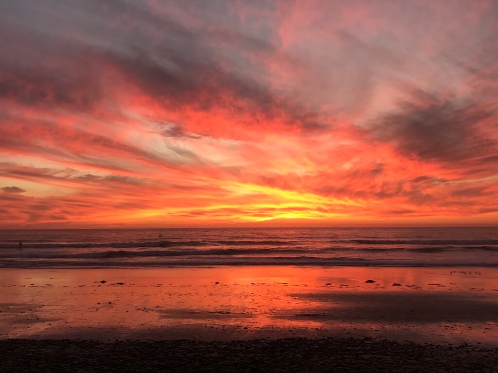 Bright orange sunset reflecting on the beach