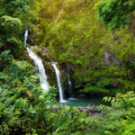 Upper Waikani Falls also known as Three Bears, a trio of large waterfalls amid rocks & lush vegetation with a popular swimming hole, off the Road to Hana Highway, Maui, Hawaii, USA