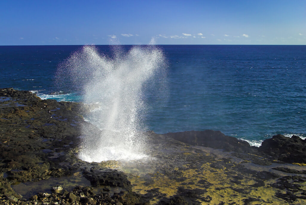 Water from the ocean being sprayed out of the Spouting Horn, an old volcanic lava tube on the island of Kauai in Hawaii.