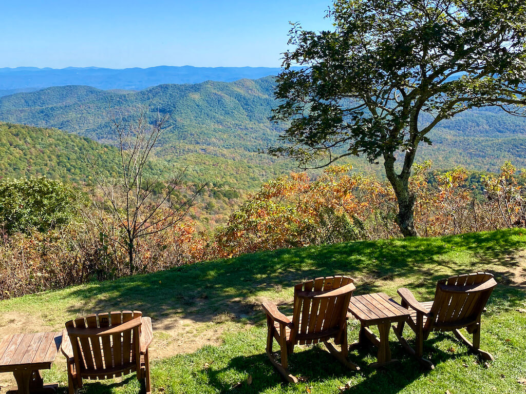 wooden Adirondack chairs looking out over Blue Ride Mountains in fall
