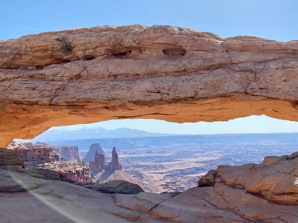 View across desert and through a scenic arch at Canyonlands