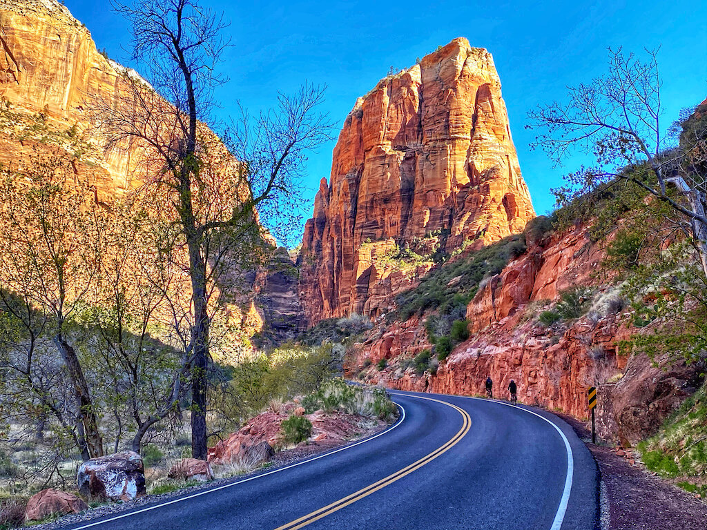 Road view with large granite cliffs in background at sunset