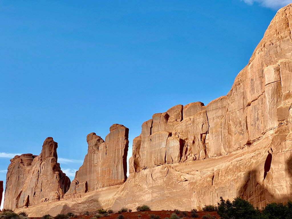 sheer sandstone formations in arches at sunset