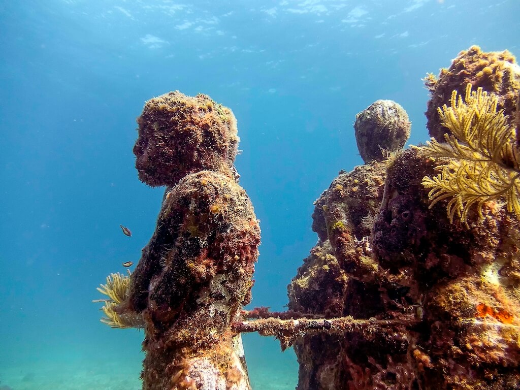 Underwater statues covered with moss at the underwater museum near Cancun, one of the best things to do in Yucatan