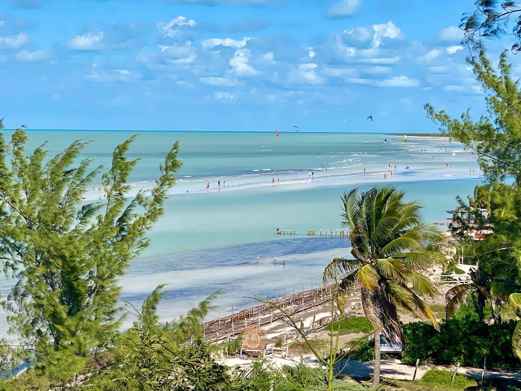 Panoramic view of shallow green water and kite surfers on Holbox island, one of the best things to do in Yucatan