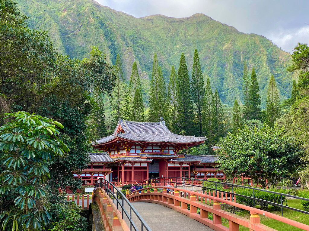 Asian temple and bridge with green cliffs behind