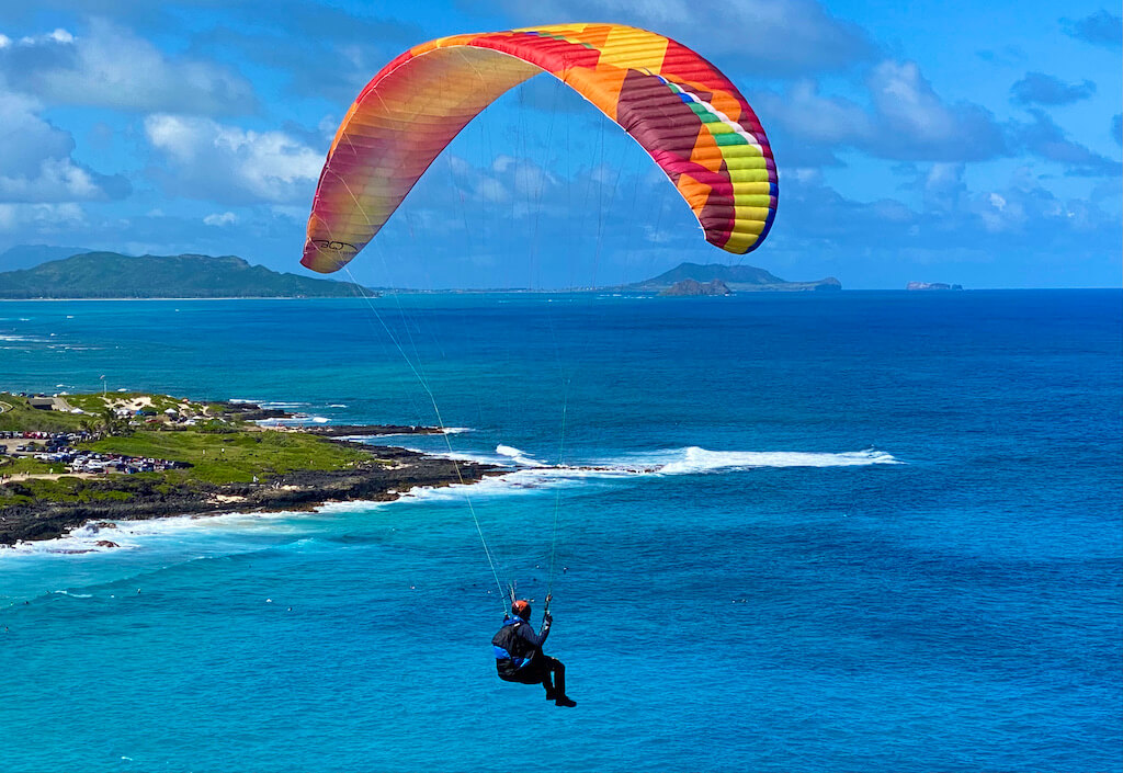 man parasailing over a bright blue ocean