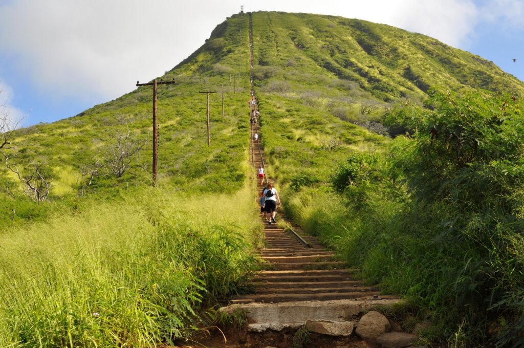 people climbing up a steep set of railroad tracks to the Koko Head Summit