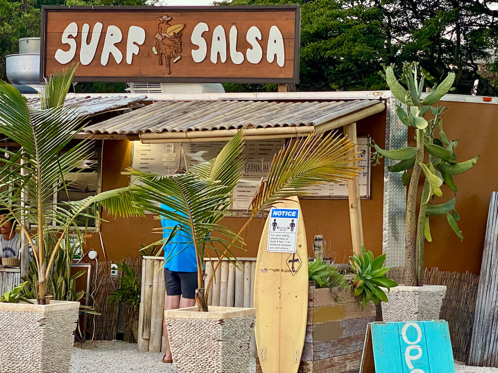 beige food truck with palm trees and surfboard. Sign says "Surf Salsa"