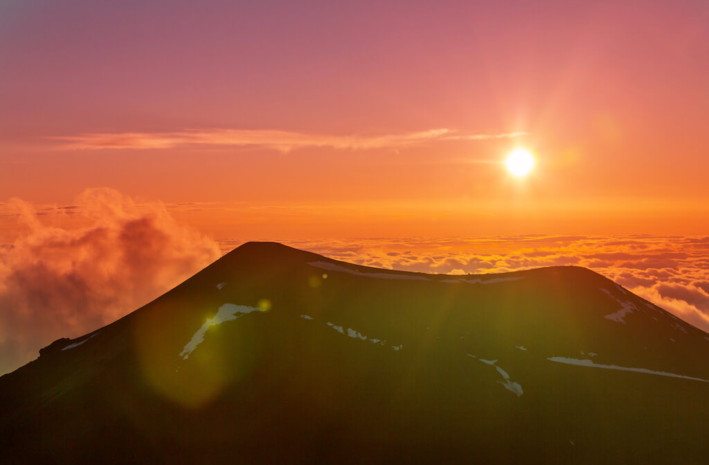 orange hazy sunset at Mauna Kea peak