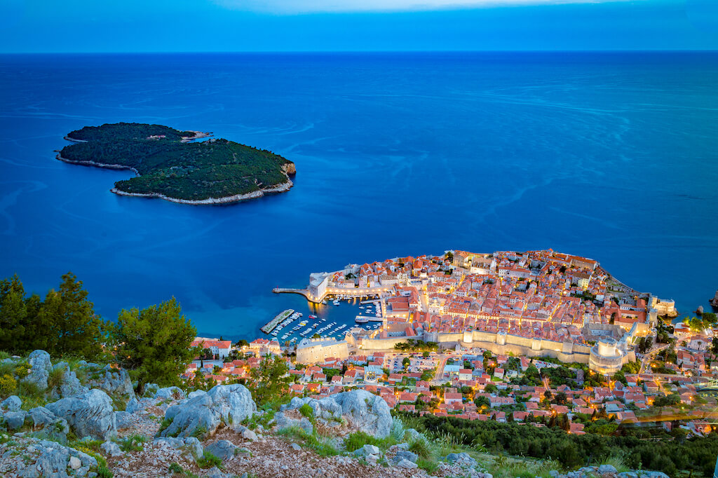 Panoramic aerial view of the historic town of Dubrovnik with Lokrum island in beautiful evening twilight at dusk, Dalmatia, Croatia