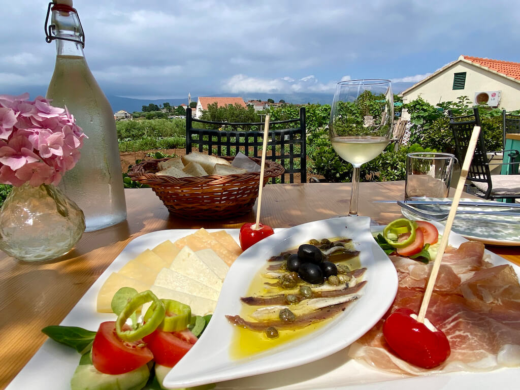 cheese plate and appetizers with wine and vineyard view on korcula island , one of the best islands in Croatia