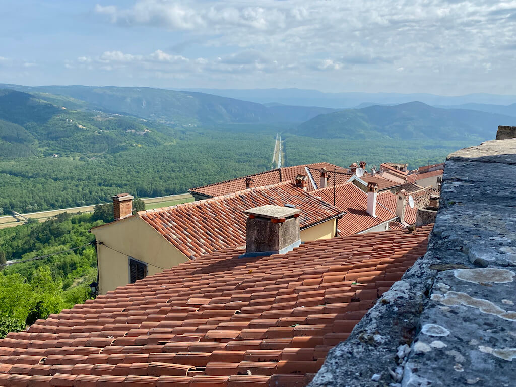 red tile roofs and green mountains in the distance