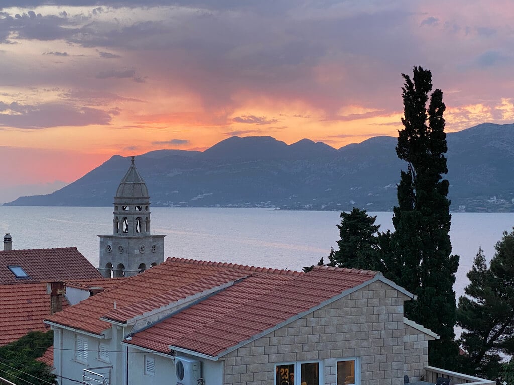 sunset over a stone tower and sea on Korcula