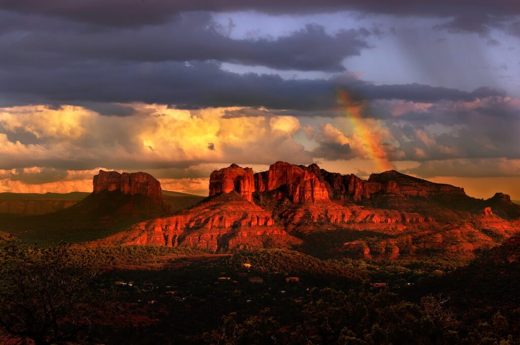 Red rock canyons in Sedona at sunset with clouds and a rainbow