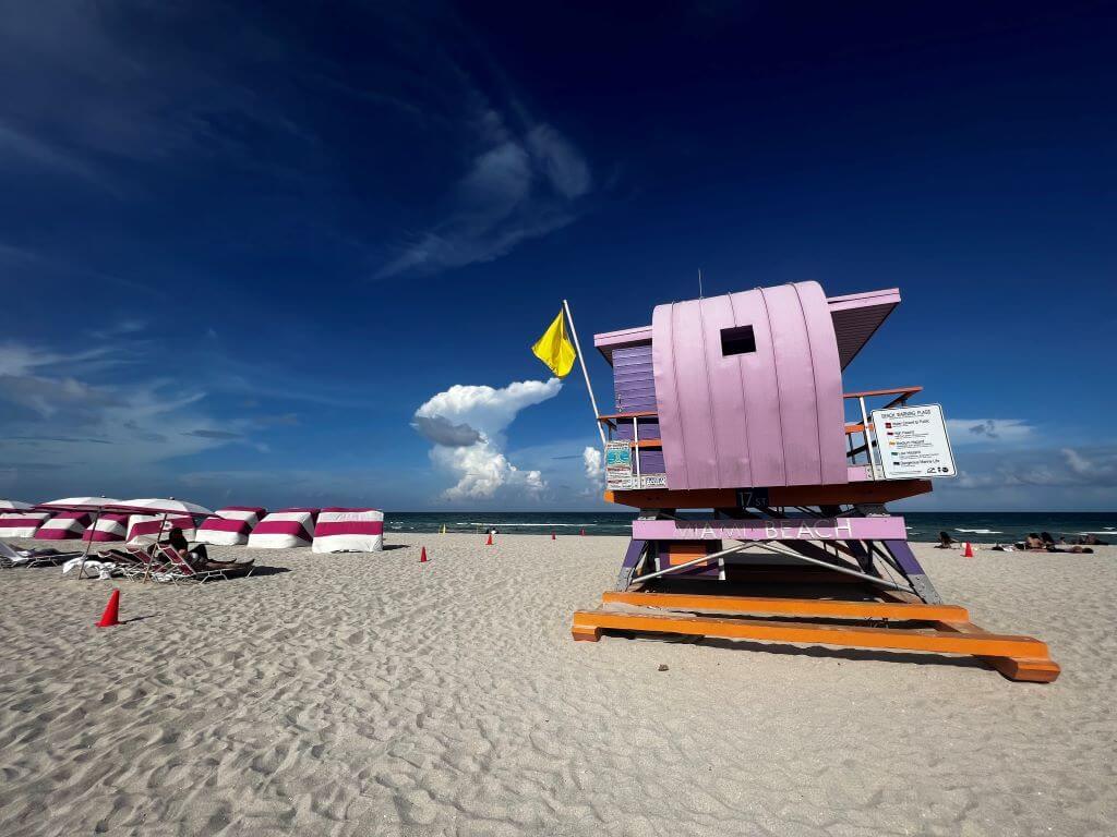 purple lifeguard station and striped cabanas on Miami Beach in February