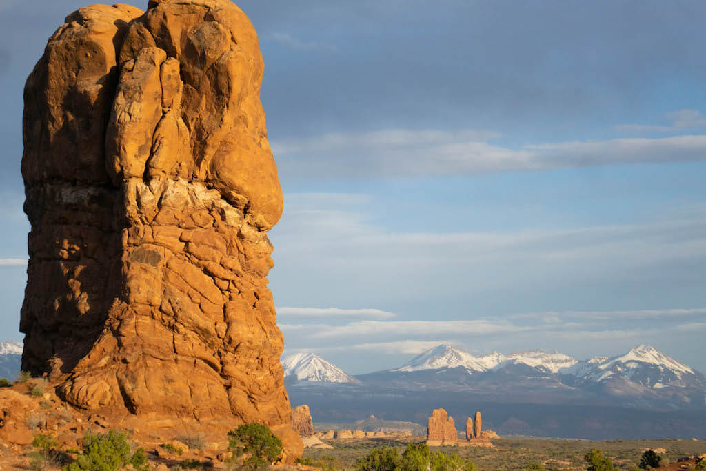 Arches National Park, orange rock formation with snow-capped La Sal mountains in background