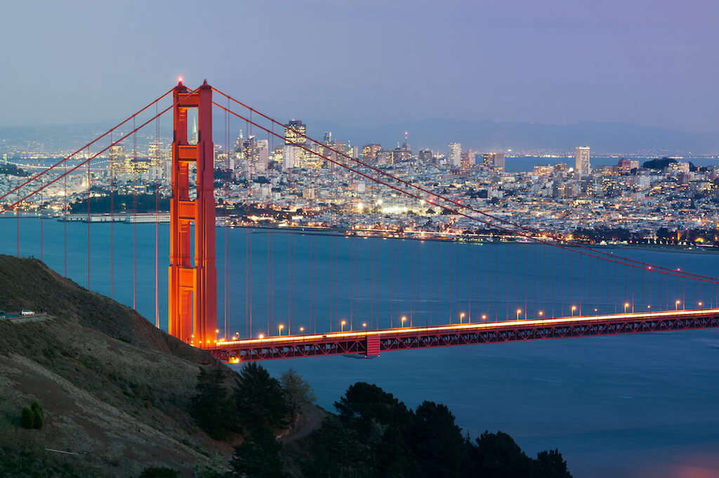 Golden Gate Bridge at dusk with illuminated city in background