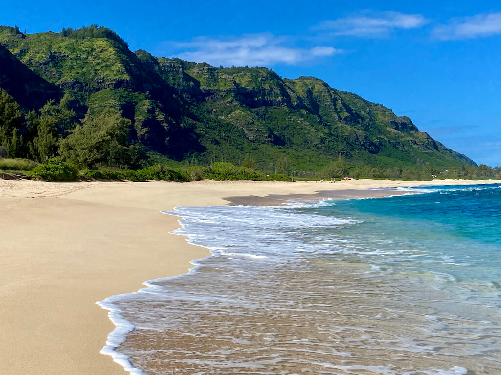 deserted beach with green cliffs in Oahu on April