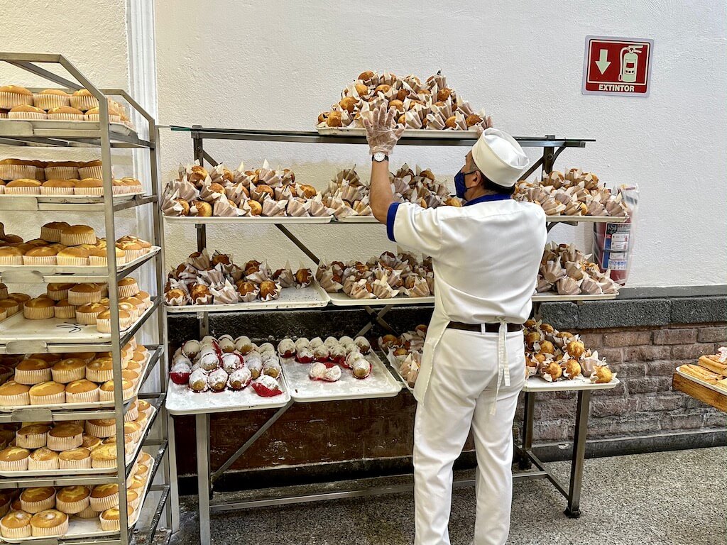 baker moving trays of pastries in a bakery