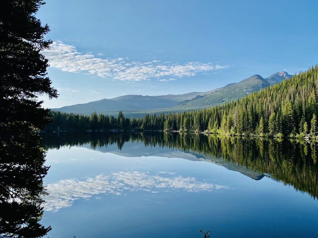 Whispy clouds reflected in Bear Lake rimmed with evergreens