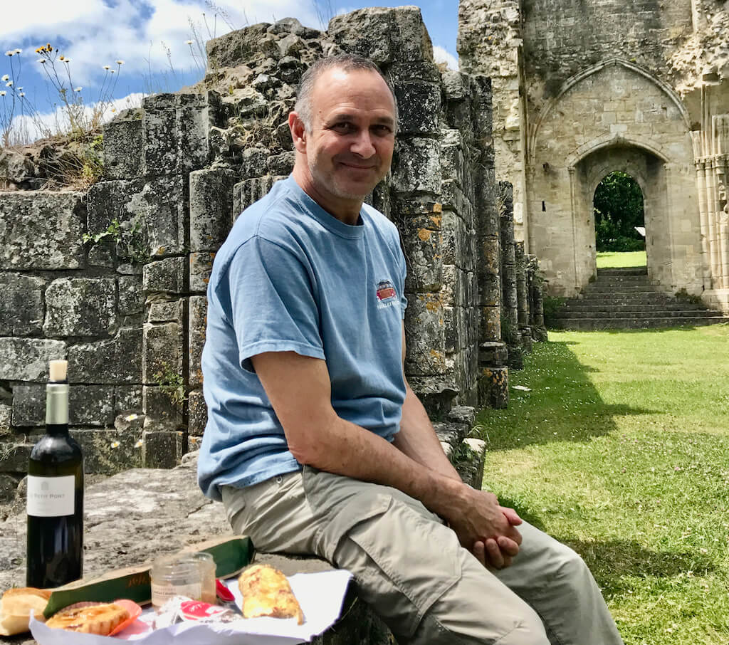 man picnicing at a ruins of an abby in Normandy