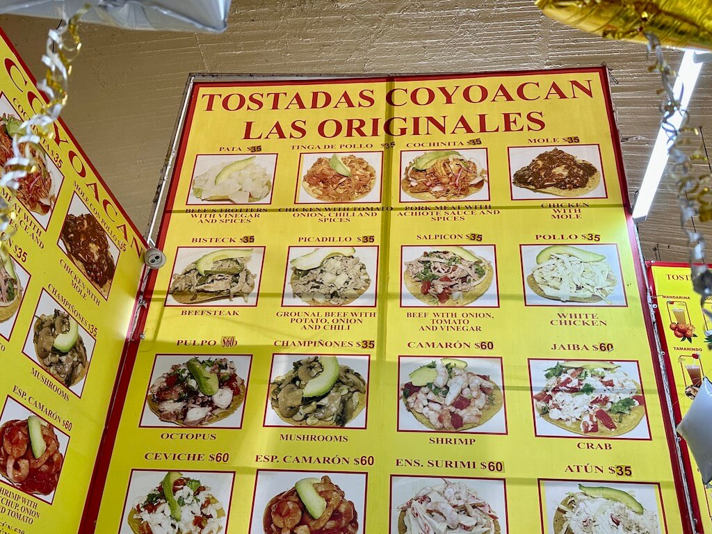Bright market sign displaying varieties of tostadas