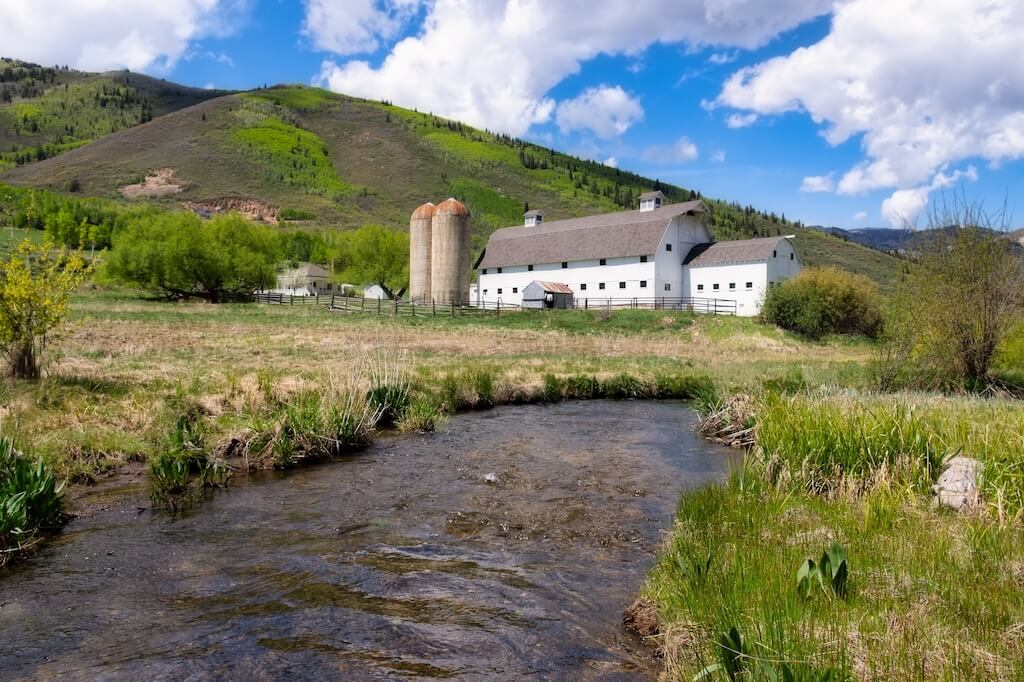 The iconic McPolin Barn in Park City Utah with a stream in the foreground