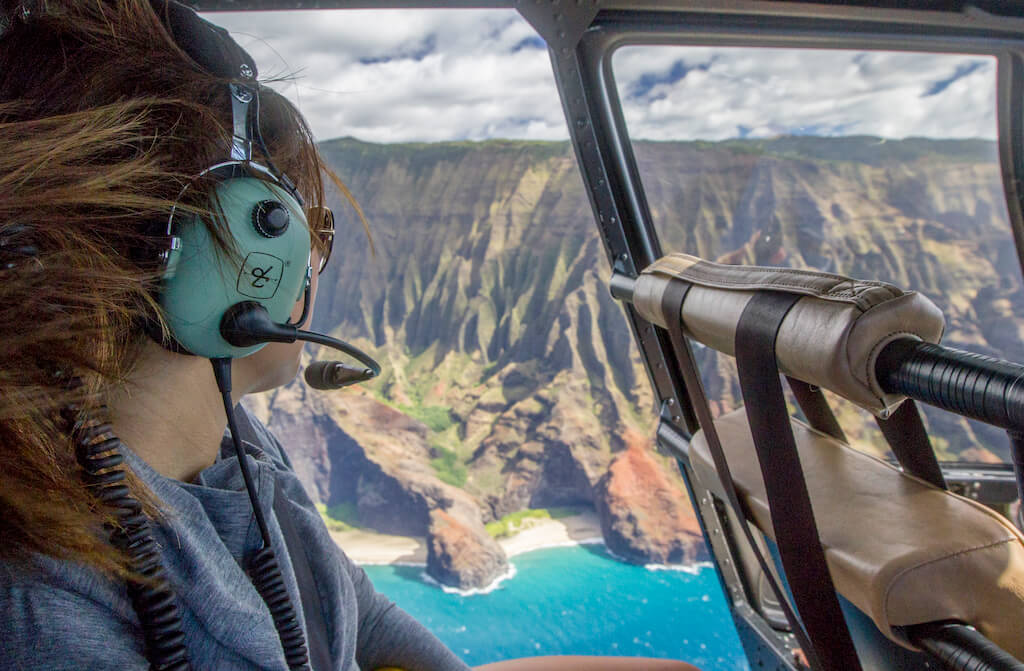 woman in a helicopter above the Na Pali coast on Hawaii