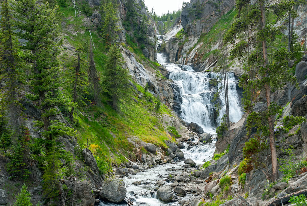 Mystic Falls on the Little Firehole River beautifully curly between rocky shores, Yellowstone National Park