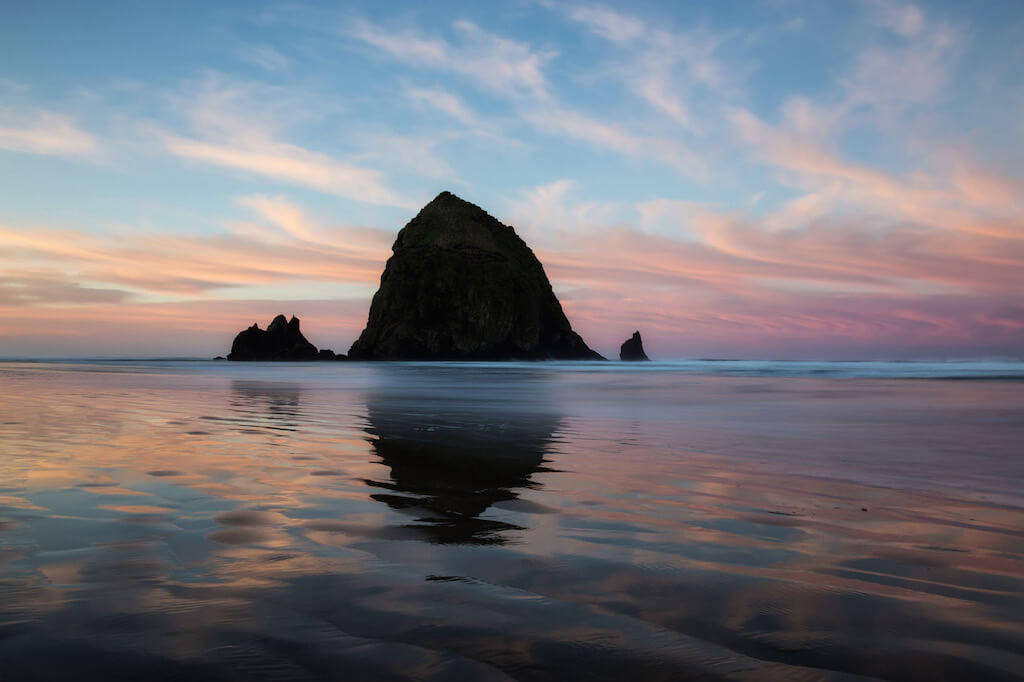Famous rock formation during a vibrant and colorful winter morning sunrise. Taken in Canon  Beach, Oregon Coast, United States of America.