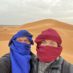 man and woman in brightly colored scarves in Sahara Desert