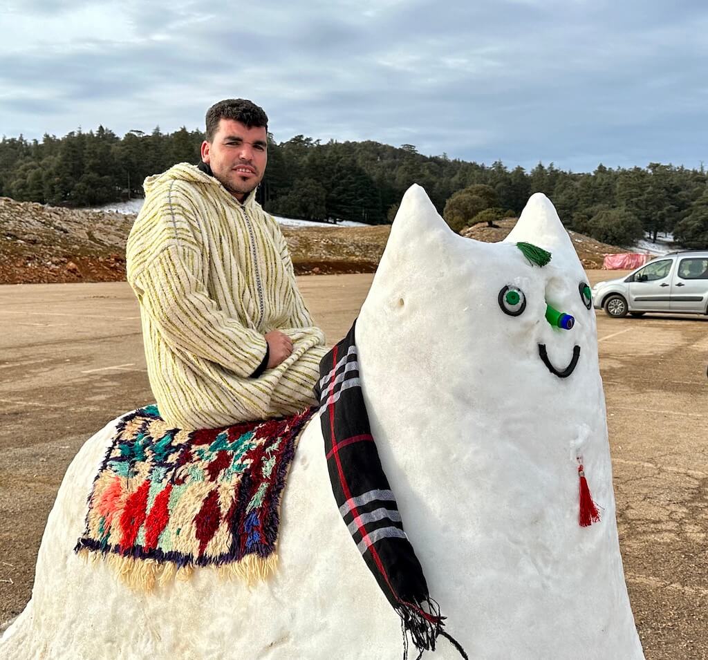 Man on a cat sculpture made out of snow in the Ifrane