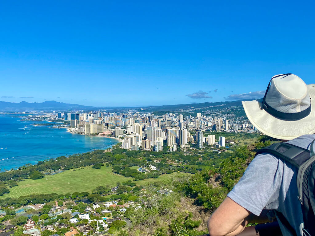 man looking out over Honolulu from Diamond Head State Park, one of the best places to visit in hawaii