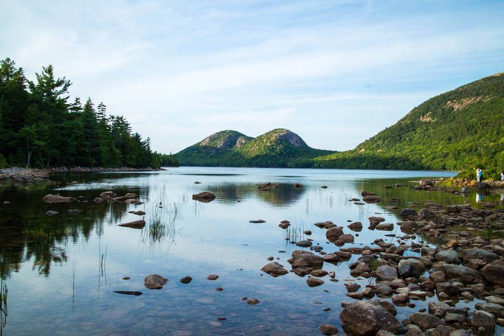 serene lake with rocks and gentle hills at Acadia National Park in August.
